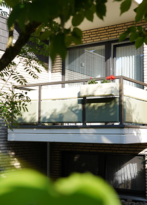 Außenaufnahme von einem Balkon mit einem Blumenkasten mit roten Blumen